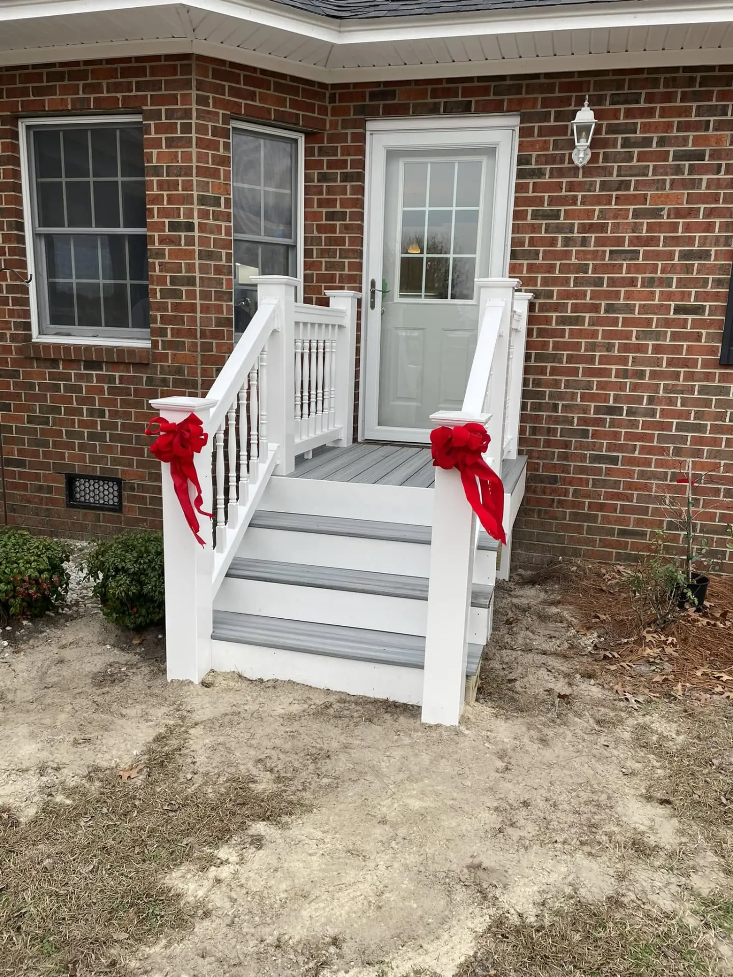 Finished front entry steps with composite decking and white railings