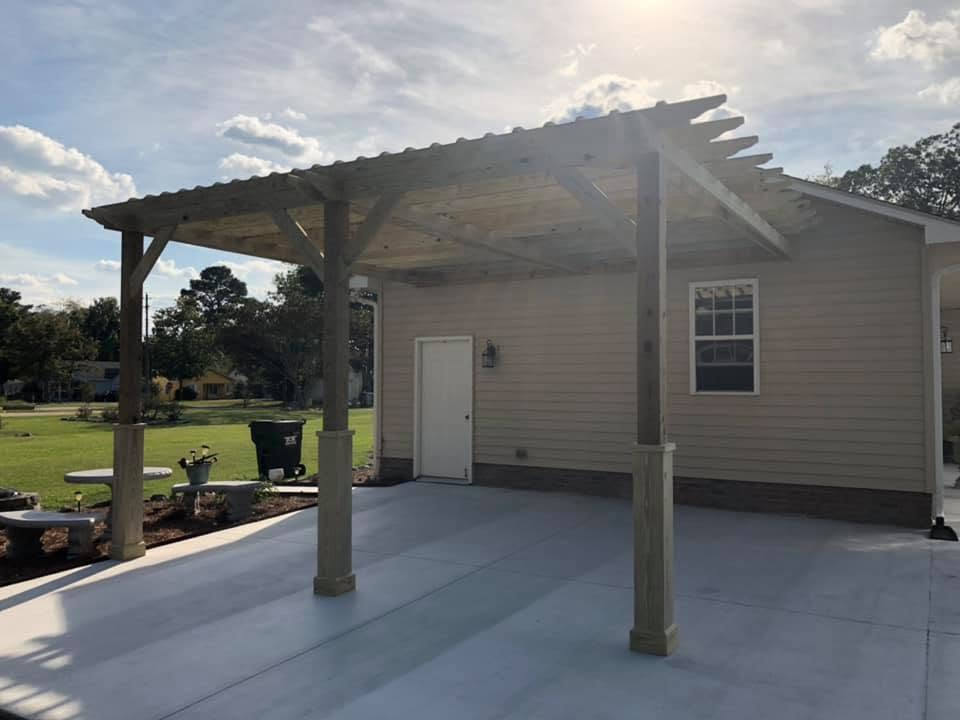 Custom timber pergola with metal roof over a new concrete patio