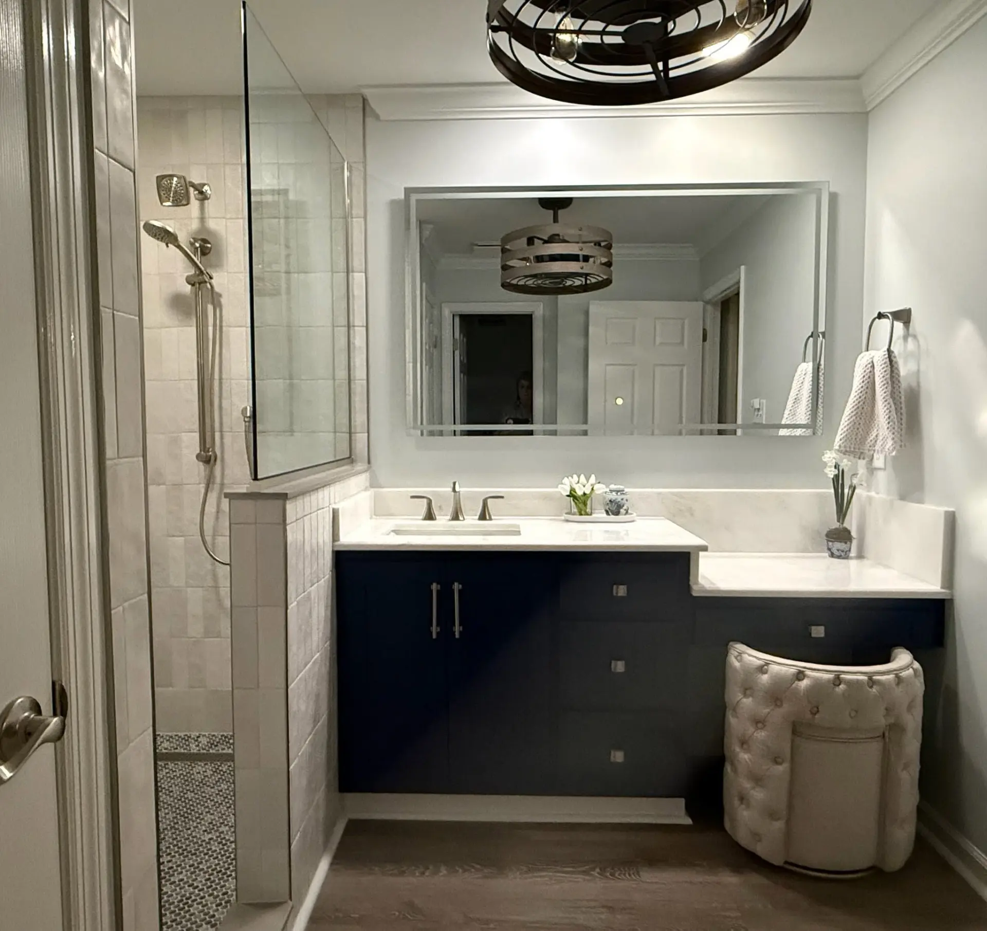 Completed bathroom remodel with tiled shower and custom dark vanity