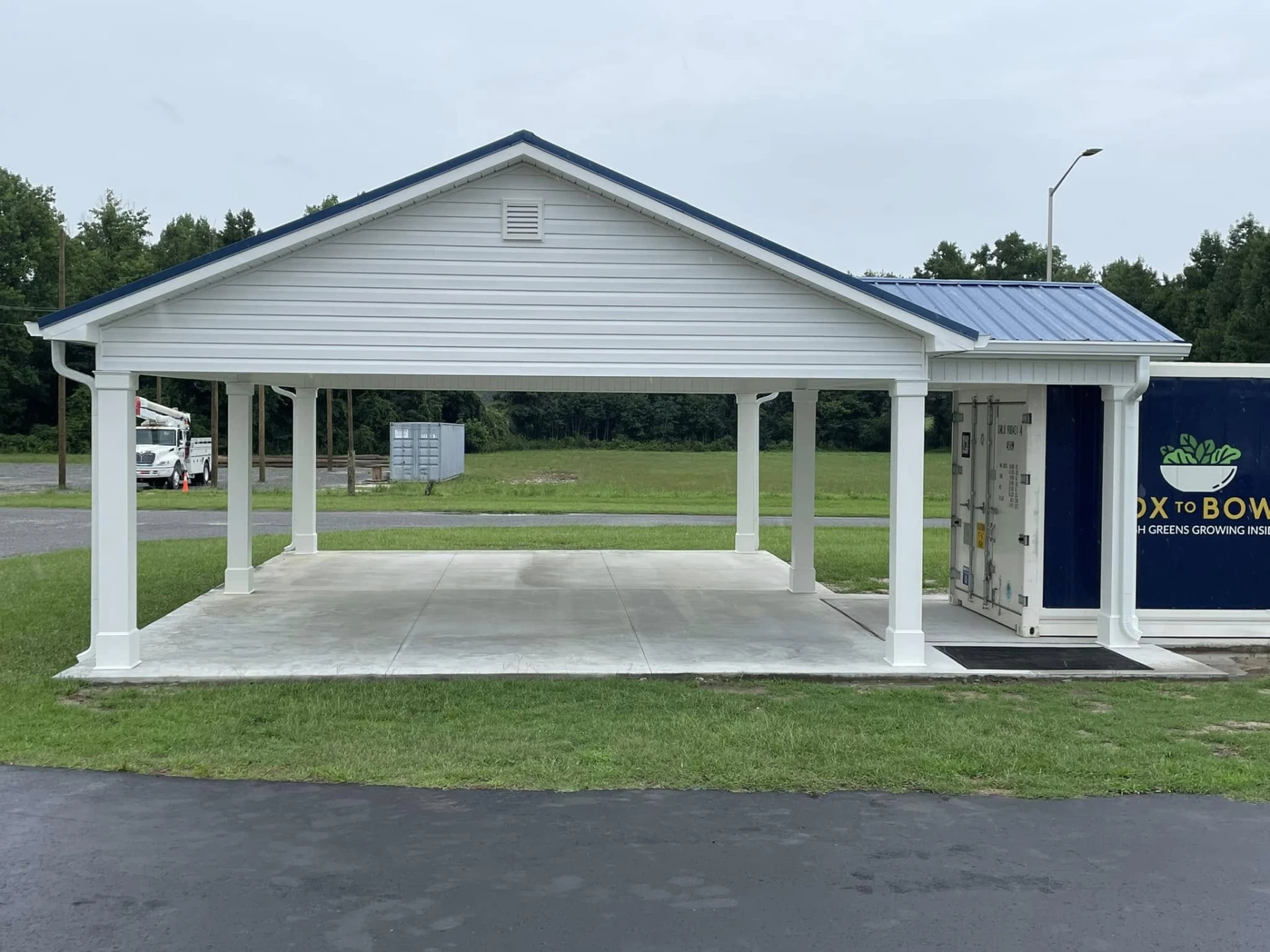 Completed commercial pavilion with metal roof, finished columns, and concrete pad